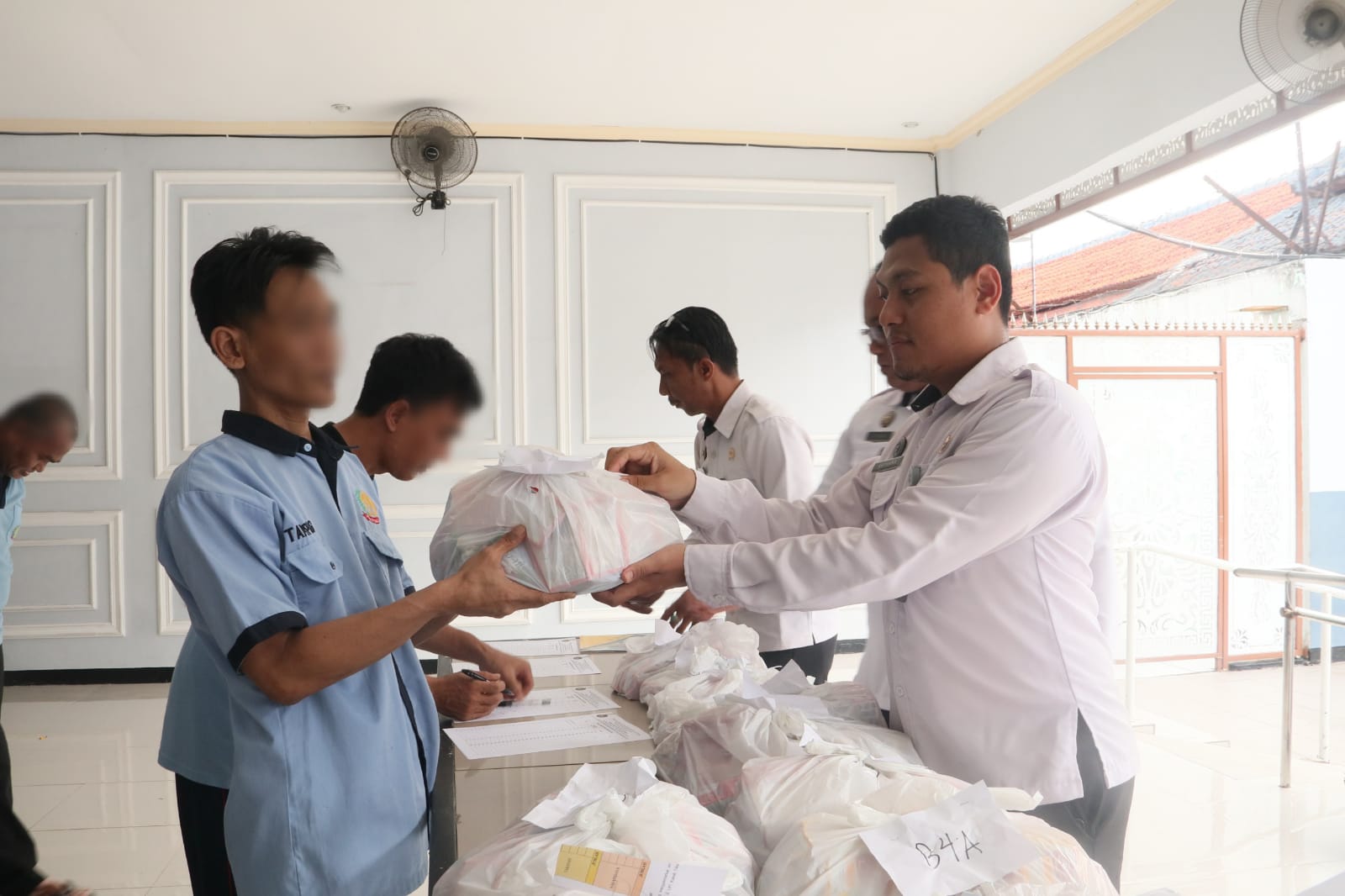 DIBAGIKAN : Petugas Rutan kelas IIB Gresik saat membagikan matras dan perlengkapan mandi kepada Warga binaan.