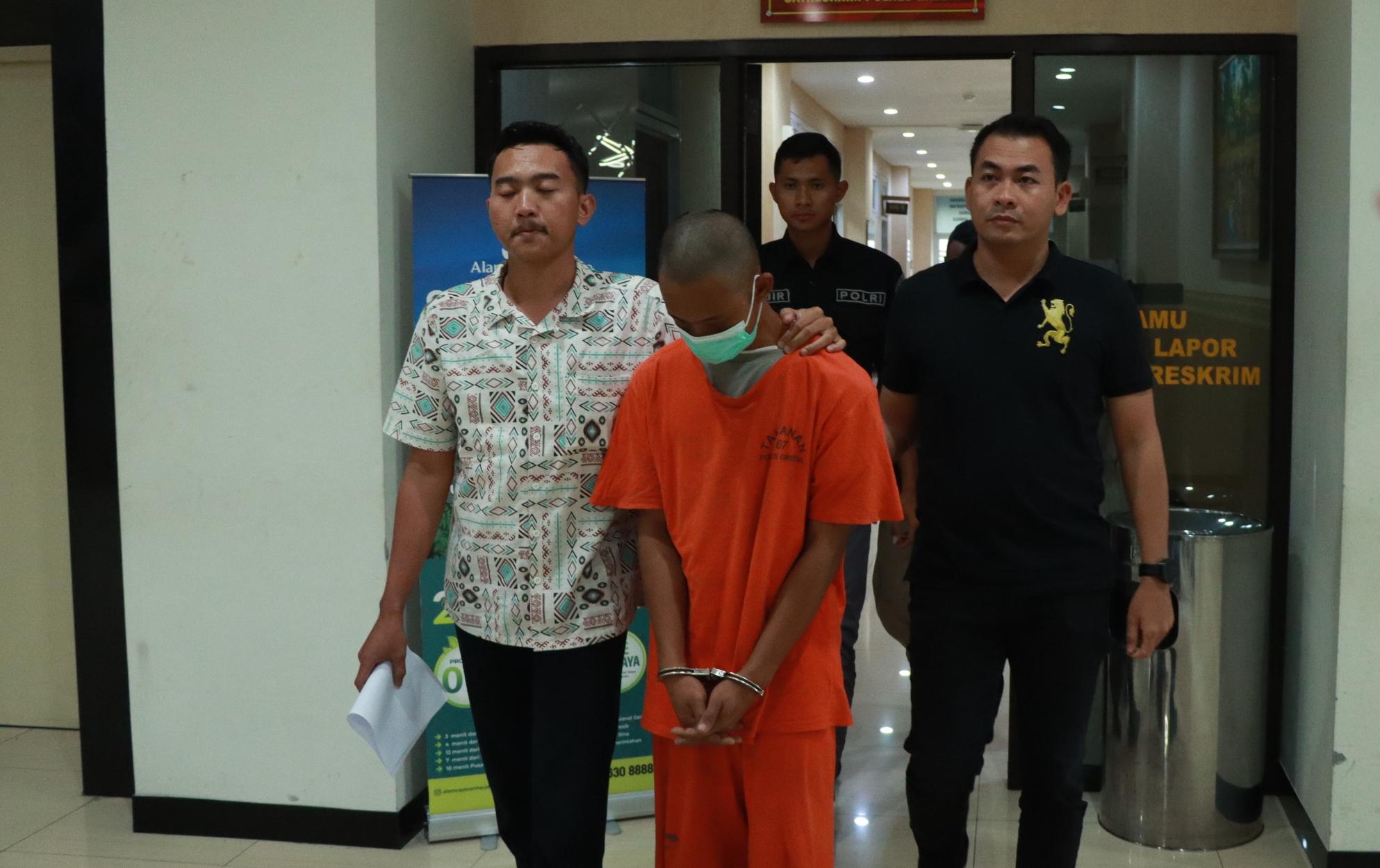 DIAMANKAN : Tersangka DF saat diamankan oleh penyidik unit PPA Satreskrim Polres Gresik untuk di tahan di Mapolres Gresik.