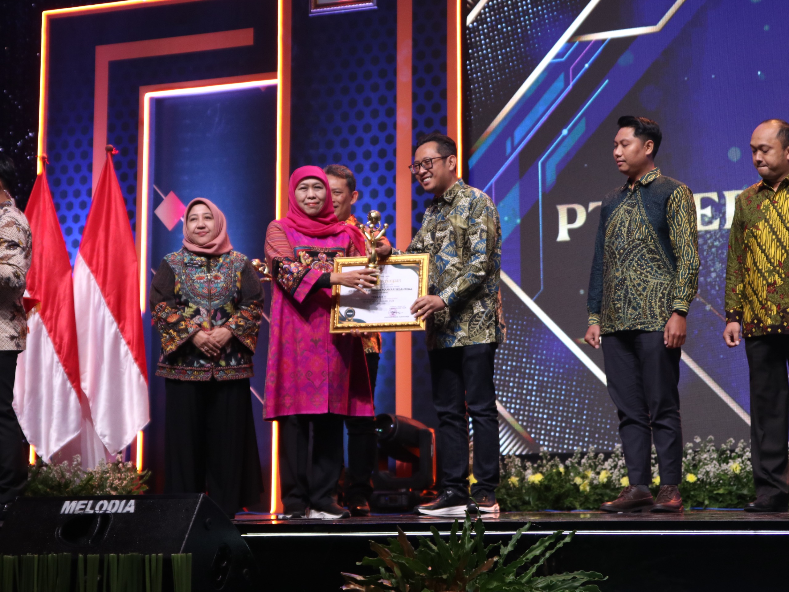 Gubernur Khofifah menyerahkan penghargaan invesment award kepada Direktur Keuangan PT BKMS, Ifan Johar Kuswahyudi.