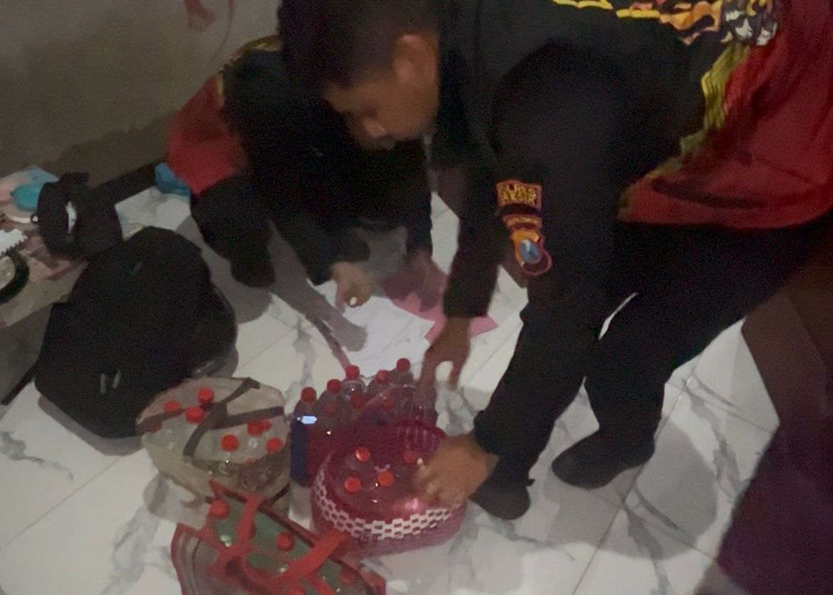 DIAMANKAN : Anggota Satuan Samapta Polres Gresik saat mengamankan puluhan botol miras dalam Operasi Tipiring di wilayah Kabupaten Gresik.