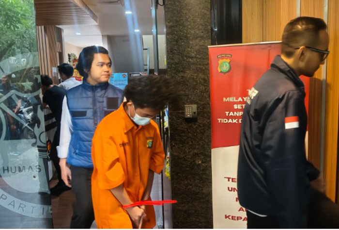 Hacker Bjorka saat digiring polisi, ia tertunduk lesu sambil menggunakan masker.