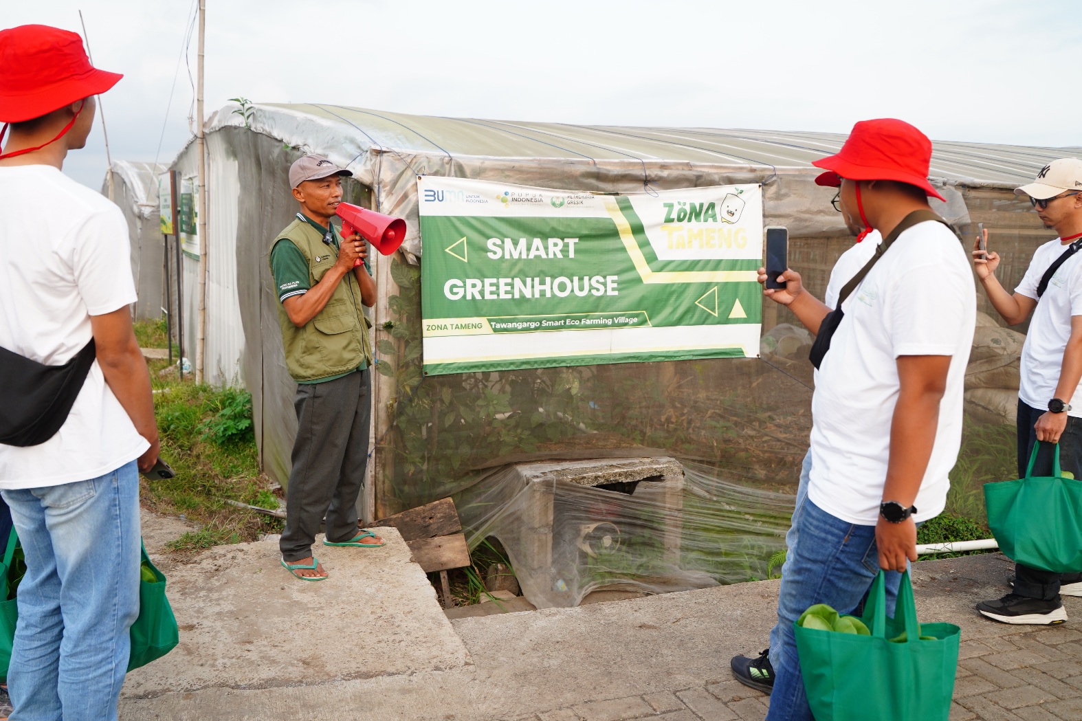 Petani binaan PG memberikan penjelasan mengenai sistem Smart Greenhouse kepada pengunjung di kawasan Program Tawangargo Smart-Eco Farming Village (TAMENG), Kabupaten Malang.