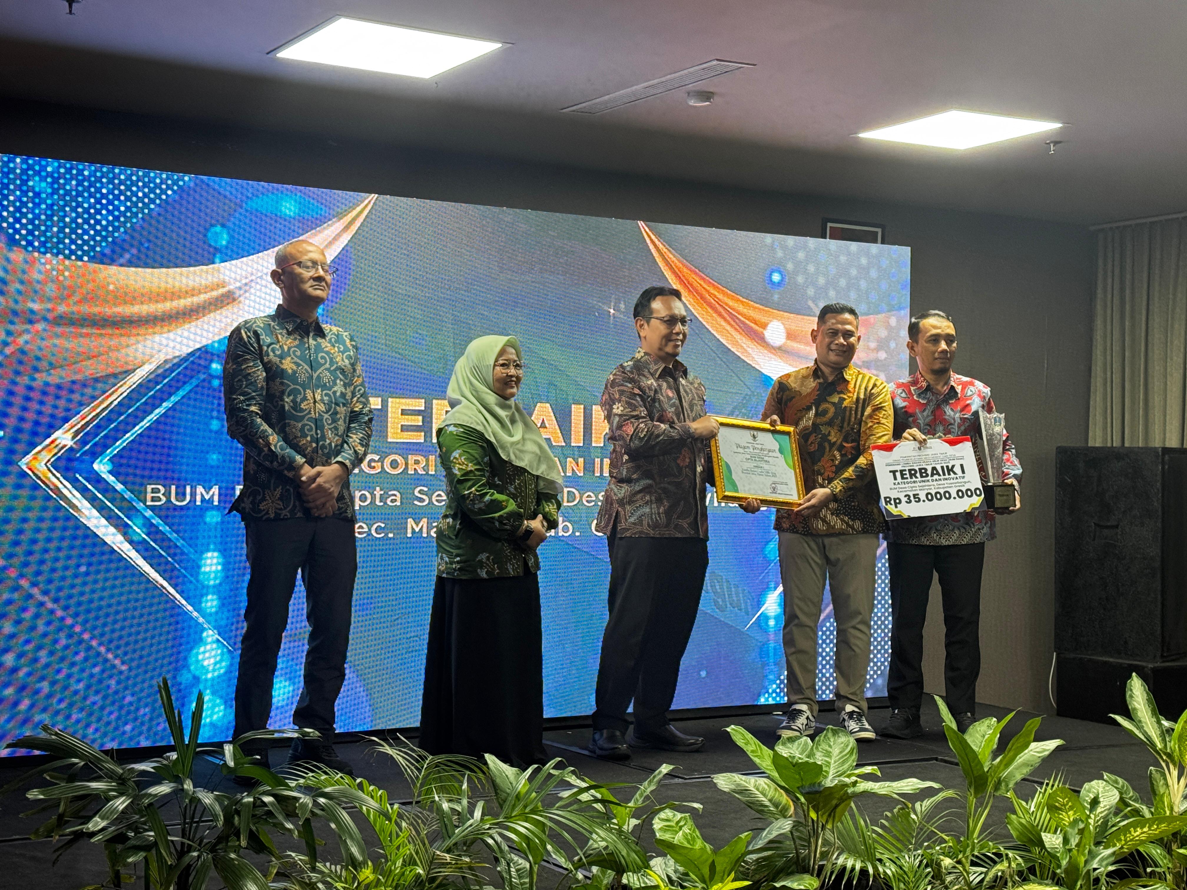 Kepala Desa Yosowilangun Abdur Rosyid bersama Direktur BUMDes Cipta Sejahtera, menerima penghargaan BUMDes terbaik.
