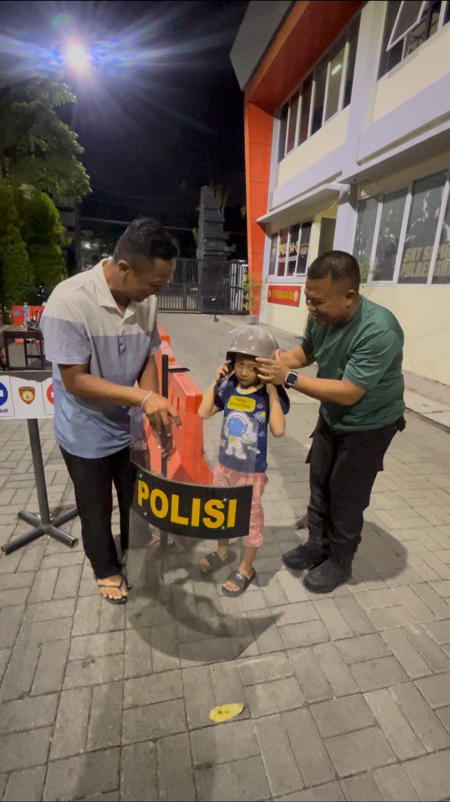 TERWUJUD: Muhaimin saat mengajak anaknya usai selesai ujian sekolah untuk mewujudkan nazarnya berfoto dengan tameng milik polisi di Mapolres Gresik.
