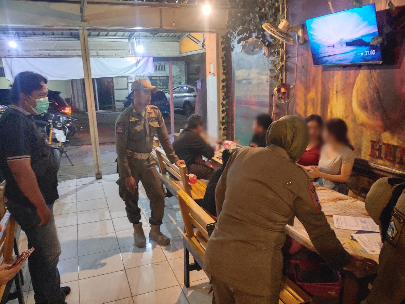 DIRAZIA : Anggota Satpol PP Kabupaten Gresik saat melakukan razia dan menyita puluhan miras di warkop dan cafe yang berada di Jalan Tambang, Gresik.