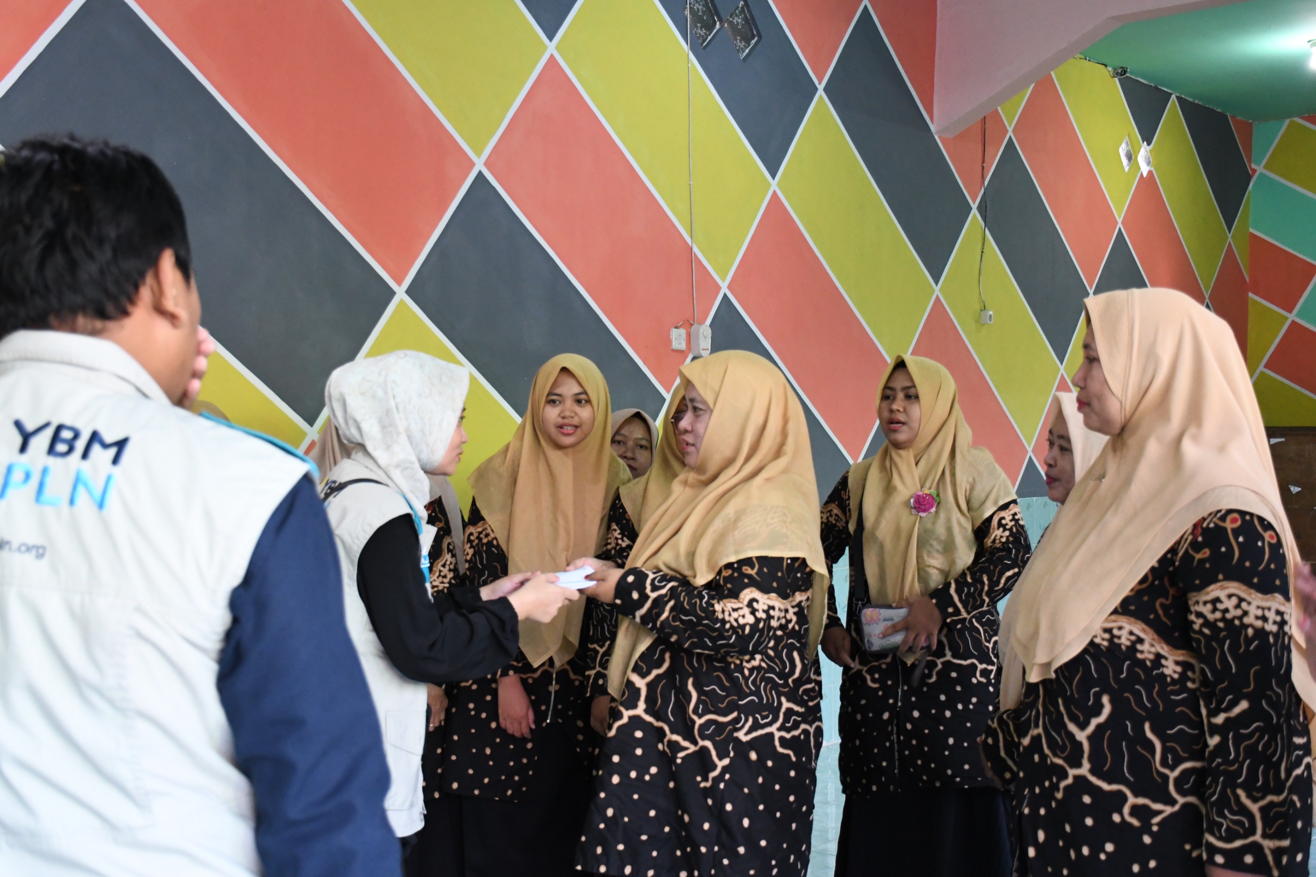 Penyerahan bantuan oleh Manajer PLN ULP Sidayu, Dwi Sri Rahayu yang juga merupakan salah satu muzakki YBM PLN UP3 Gresik kepada guru ngaji di Ujungpangkah.