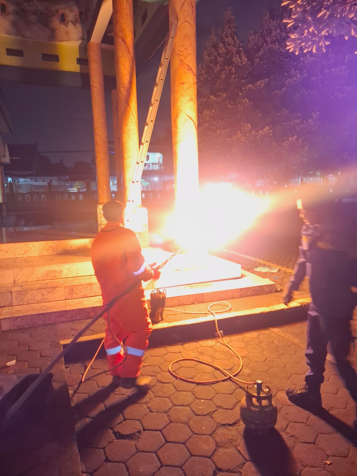 DISEMPROT API : Petugas Damkar Gresik saat melakukan evakuasi dengan menyemprot api ke sarang tawon madu di Masjid Baitur Rahman di Jalan Raya Kedanyang, Desa Kedanyang, Kecamatan Kebomas, Gresik.