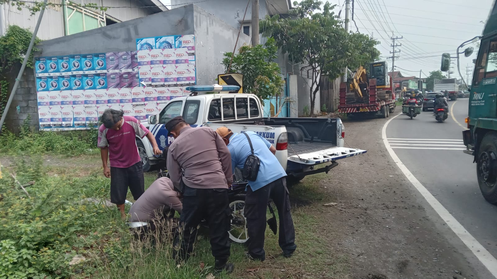 OLAH TKP : Anggota polisi saat melakukan olah TKP dan mengevakuasi korban kecelakaan di Jalan Raya Desa Padeg, Kecamatan Cerme, Gresik.