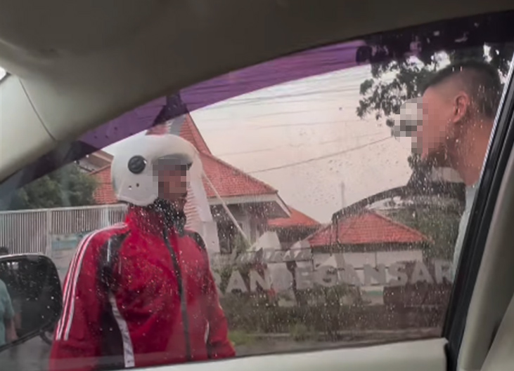 Hadang mobil di pintu tol Driyorejo, pemotor berjaket merah mengamuk mengaku terciprat air hujan dan meminta pengendara mobil minta maaf.