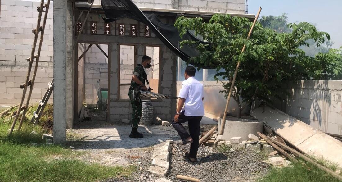 PENYEMPROTAN : Koramil Manyar melakukan penyemprotan di rumah-rumah warga.