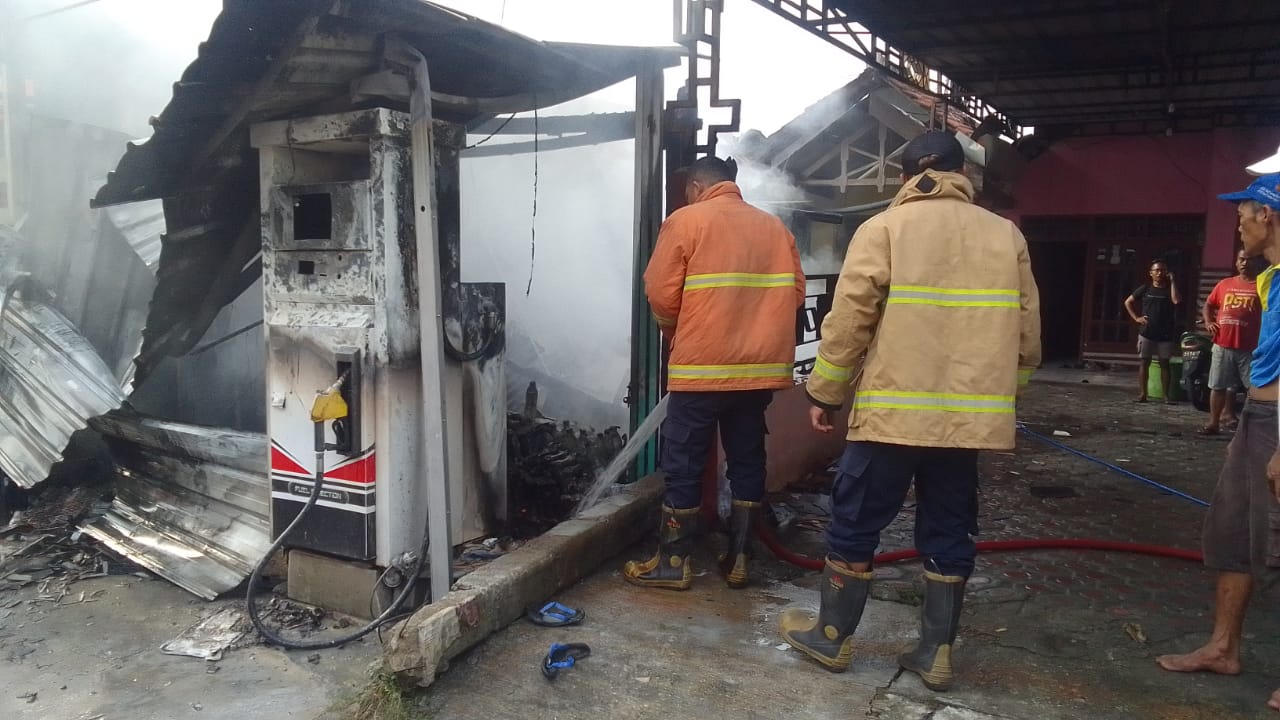 PEMADAMAN : Petugas Damkar Gresik saat melakukan pemadaman kebaran Toko Klontong di Tepi Jalan Desa Tanjungan, Kecamatan Driyorejo, Gresik.