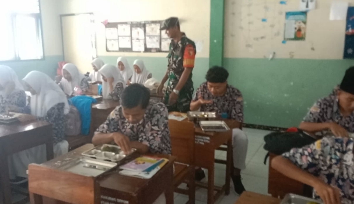 MENINJAU : Babinsa Koramil Sidayu meninjau program makan siang gratis di SMA Kanjeng Sepuh, Gresik.