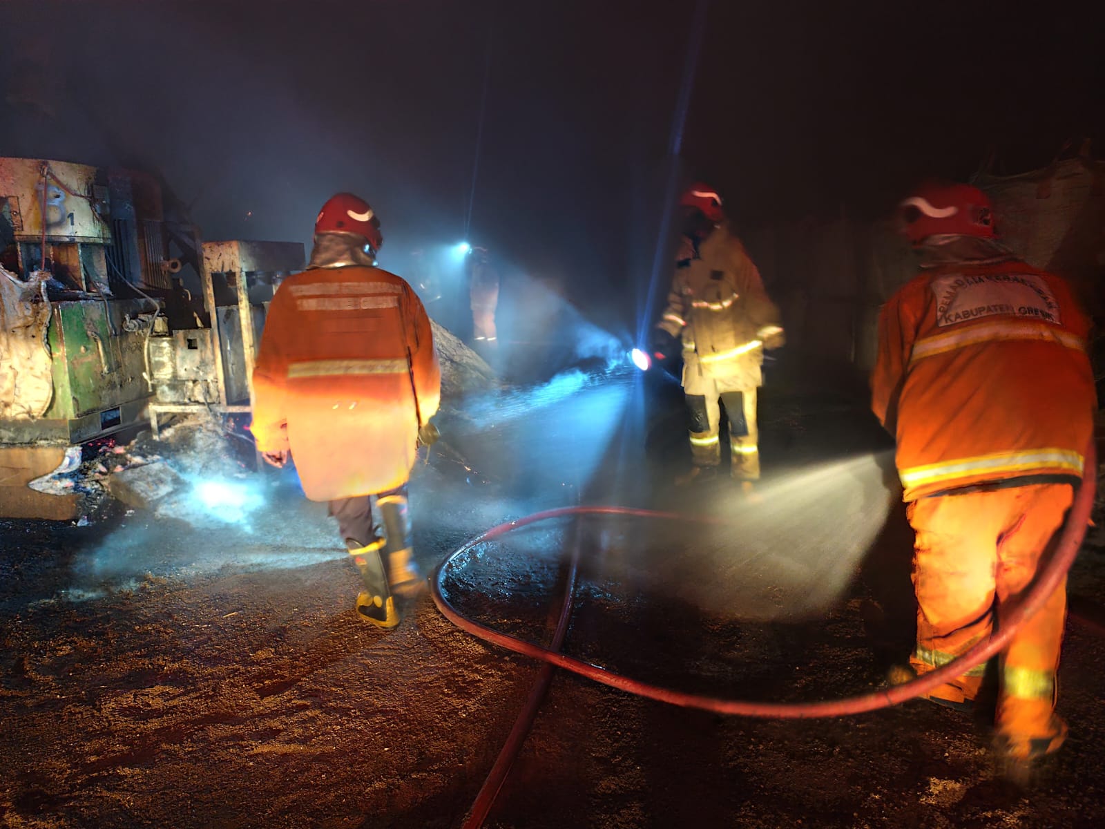 PEMADAMAN: Petugas Damkar Gresik saat melakukan pemadaman kebakaran gudang serbuk kayu di Desa Roomo, Kecamatan Manyar, Gresik.