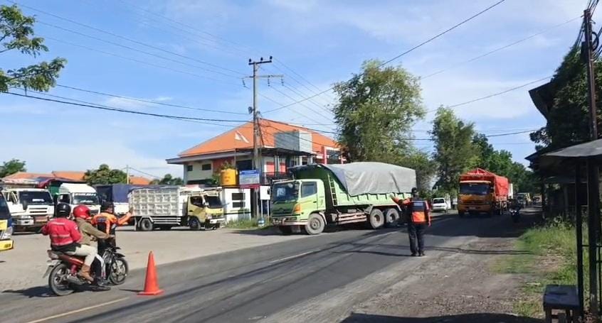 SUASANA: Petugas Dishub Gresik yang mengarahkan truk untuk masuk ke Ngawen, Kecamatan Sidayu Gresik. (DOK/RADAR GRESIK)