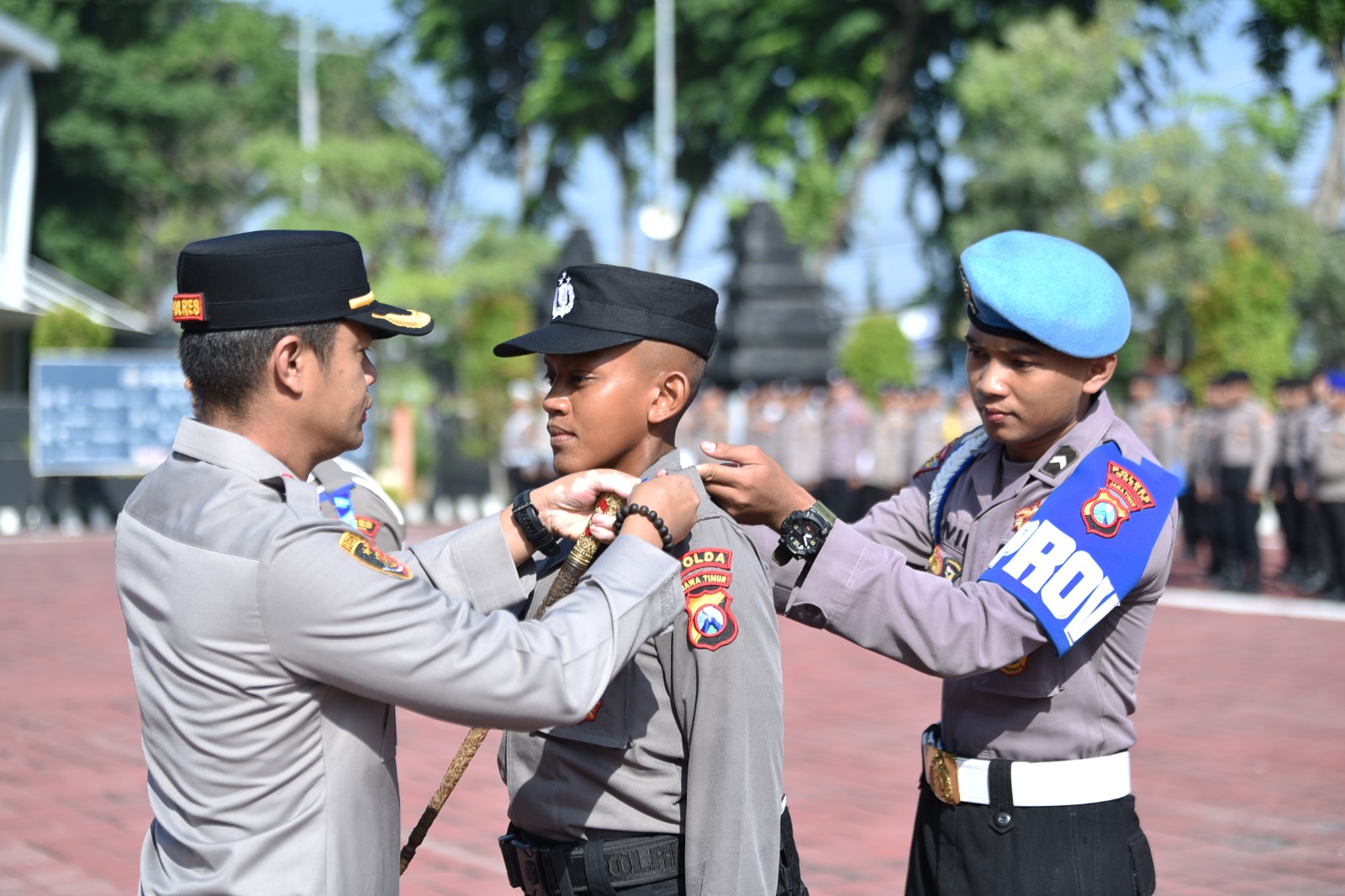 DITERJUNKAN: Kapolres Gresik AKBP Rovan Richard Mahenu saat melakukan penyematan pita latihan kerja kepada perwakilan siswa Diktuk Bintara Polri 2025 di halaman Mapolres Gresik.
