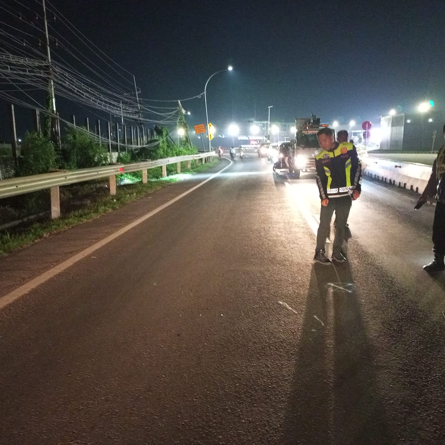 OLAH TKP : Anggota kepolisian saya melakukan olah TKP dan evakuasi korban kecelakaan di Jalan Raya Deandles, tepatnya di timur pintu masuk kawasan industri JIIPE,