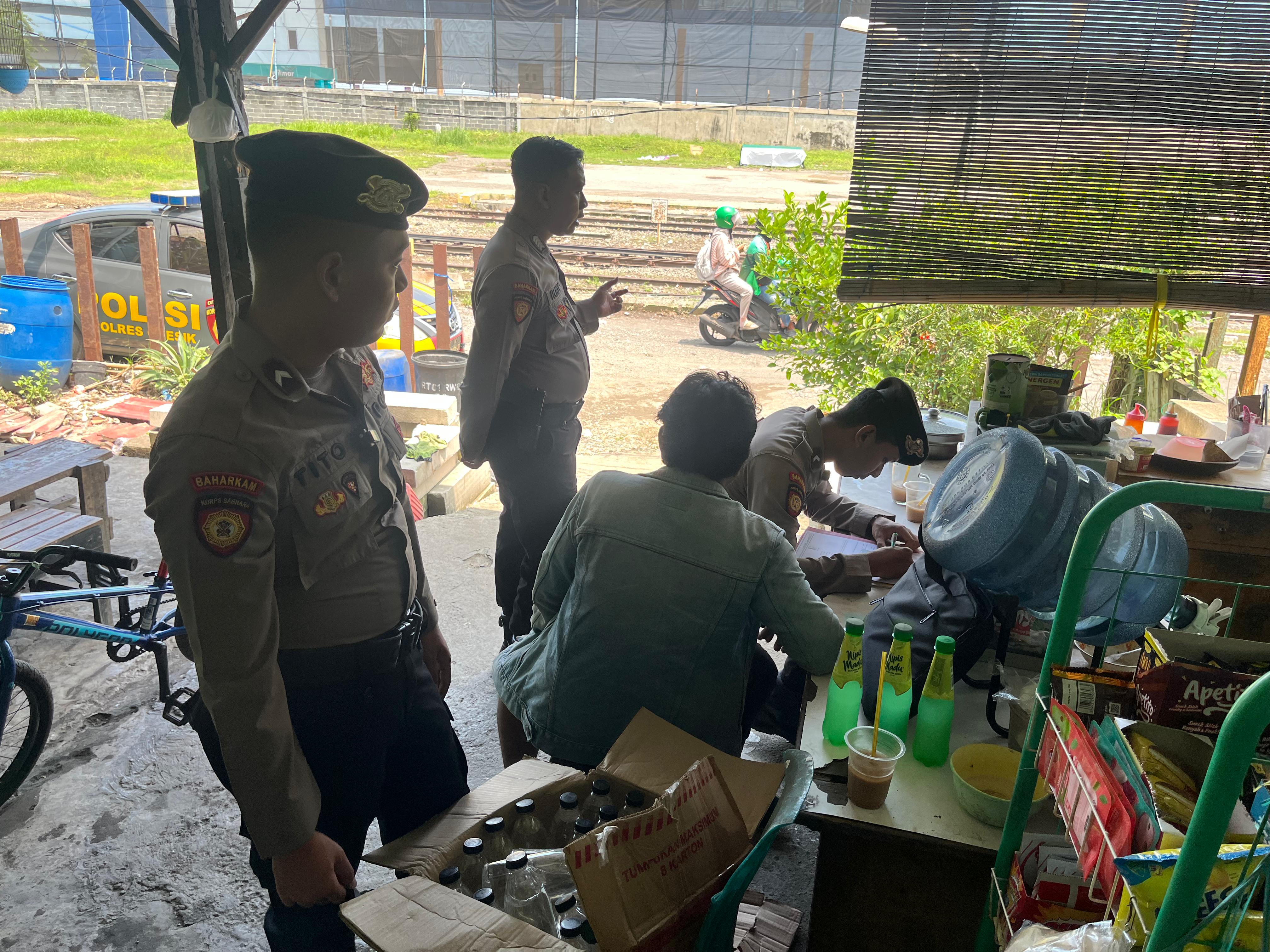 DIGREBEK : Anggota Sat Samapta Polres Gresik saat melakukan penggerebekan penjual miras di dekat Stasiun Indro, Kecamatan Gresik.