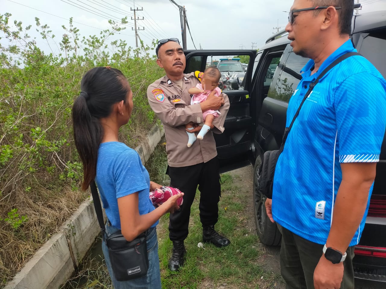 DISELAMATAKAN : Anggota Polsek Manyar saat melakukan penyelamatan bayinyang diduga akan di buang orang tuanya dinlinggir jalan, Betoyo Kauman, Kecamatan Manyar , Gresik.