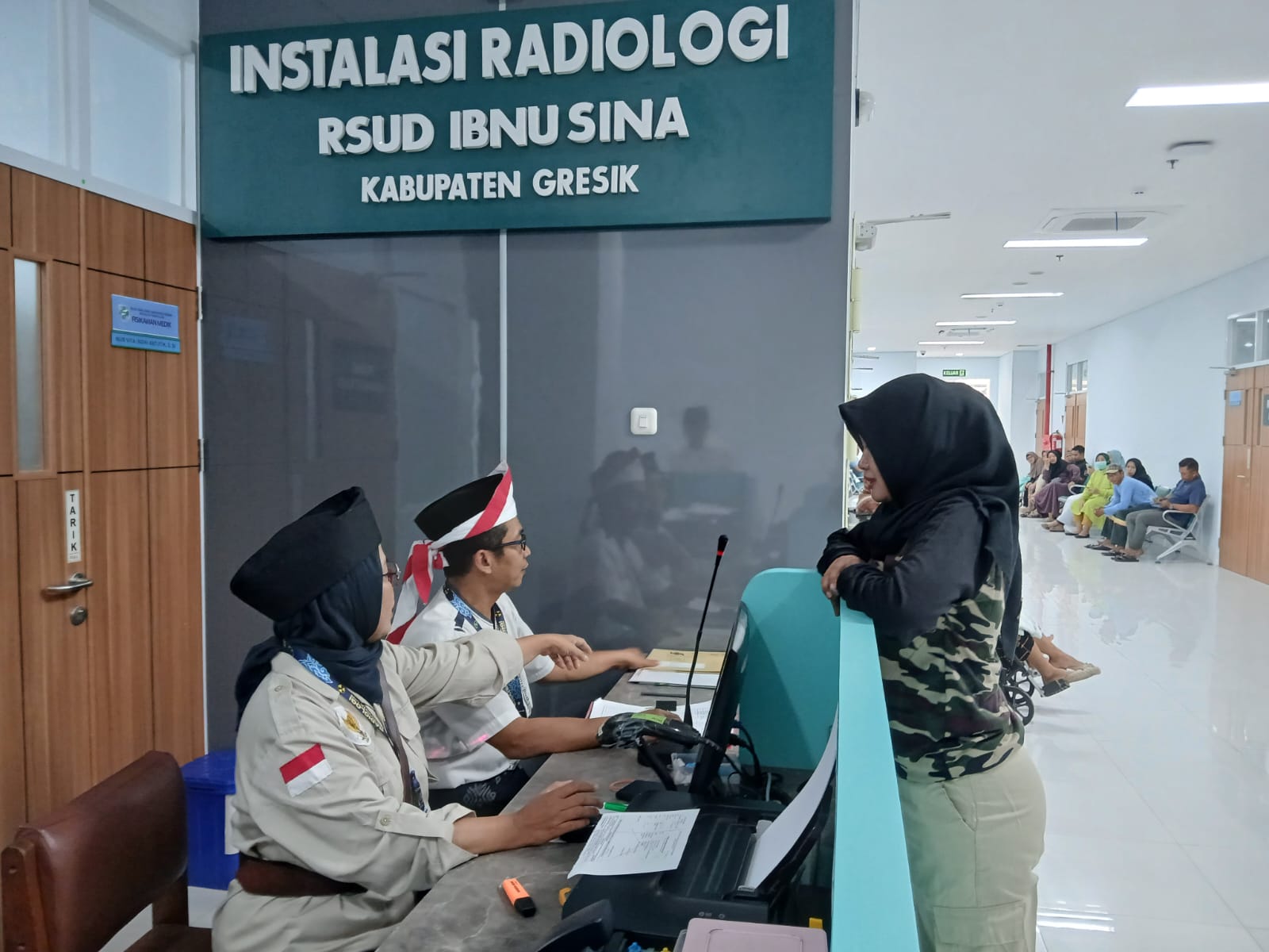 MEMERIKSA: Dokter Radiologi RSUD Ibnu Sina Gresik saat memeriksa pasien sambil mengenakan atribut tokoh pahlawan.