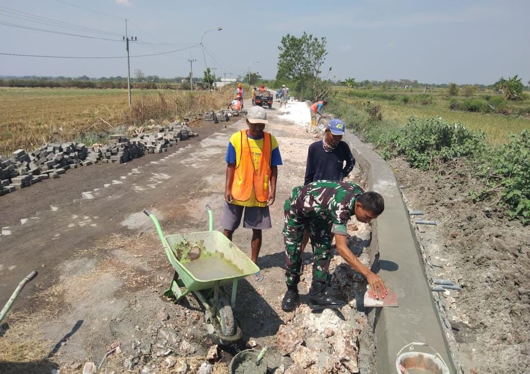 BERSAMA : Babinsa Wringinanom bersama warga melakukan gotong royong tepi sungai.