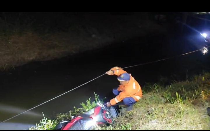 EVAKUASI : Petugas Damkarla Gresik saat melakukan evakuasi motor pengendara yang terperosok masuk parit di Jalan Raya Banjarsari, Kecamatan Cerme, Gresik.