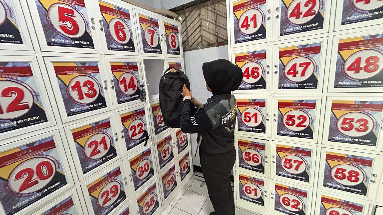 PERKETAT PENGAMANAN : Petugas Rutan Kelas IIB m Gresik saat menaruh barang pribadi di loker barang dan harus mengisi barcode melalui Handphone bagi petugas.