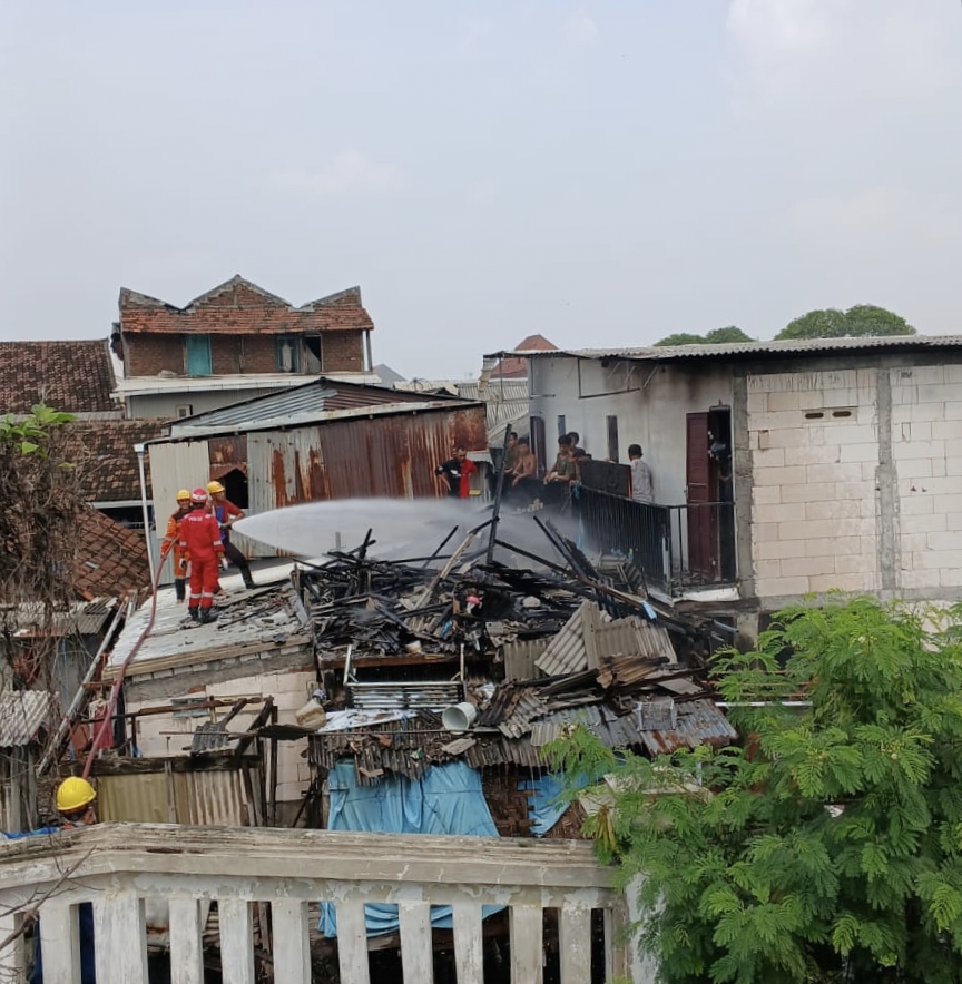 PEMADAMAN : Petugas gabungan dan Damkar Kabupaten Gresik serta warga saat melakukan pemadaman kebakaran sebuah rumah di Jalan Harun Thohir TKA No 22, RT 3/ RW 4, Desa Pulopancikan, Kecamatan Gresik.