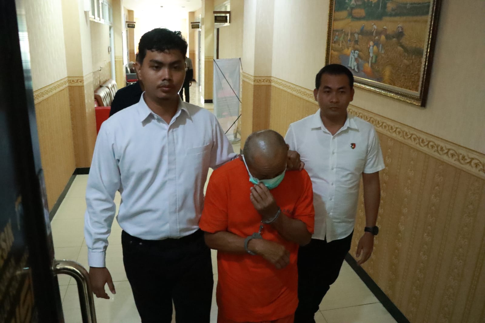 DIGELANDANG: Penyidik Unit PPA Satreskrim Polres Gresik saat menggelandang tersangka SMI untuk ditahan di Mapolres Gresik.