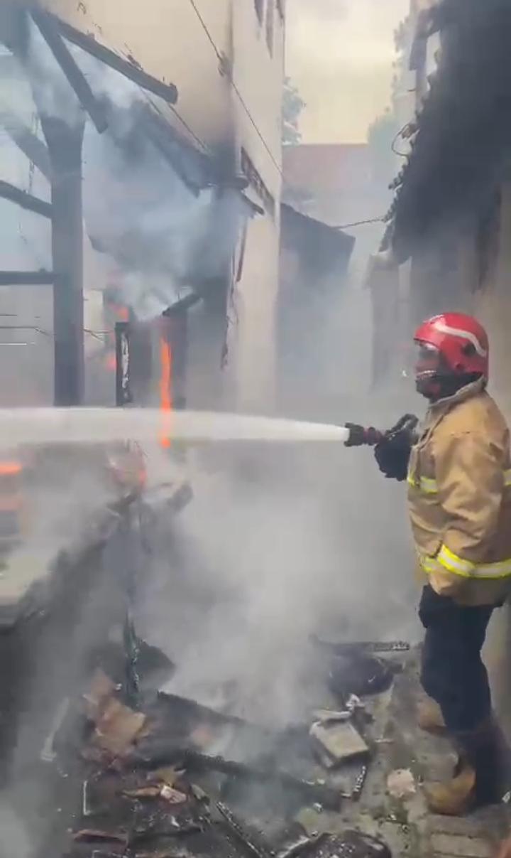 PEMADAMAN : Petugas Damkar Gresik saat melakukan pemadaman kebaran sebuah rumah di Jalan Sunan Giri Gg.V No.26 RT 002/RW 005 , Kelurahan Kawisanyar, Kecamatan Kebomas, Gresik.