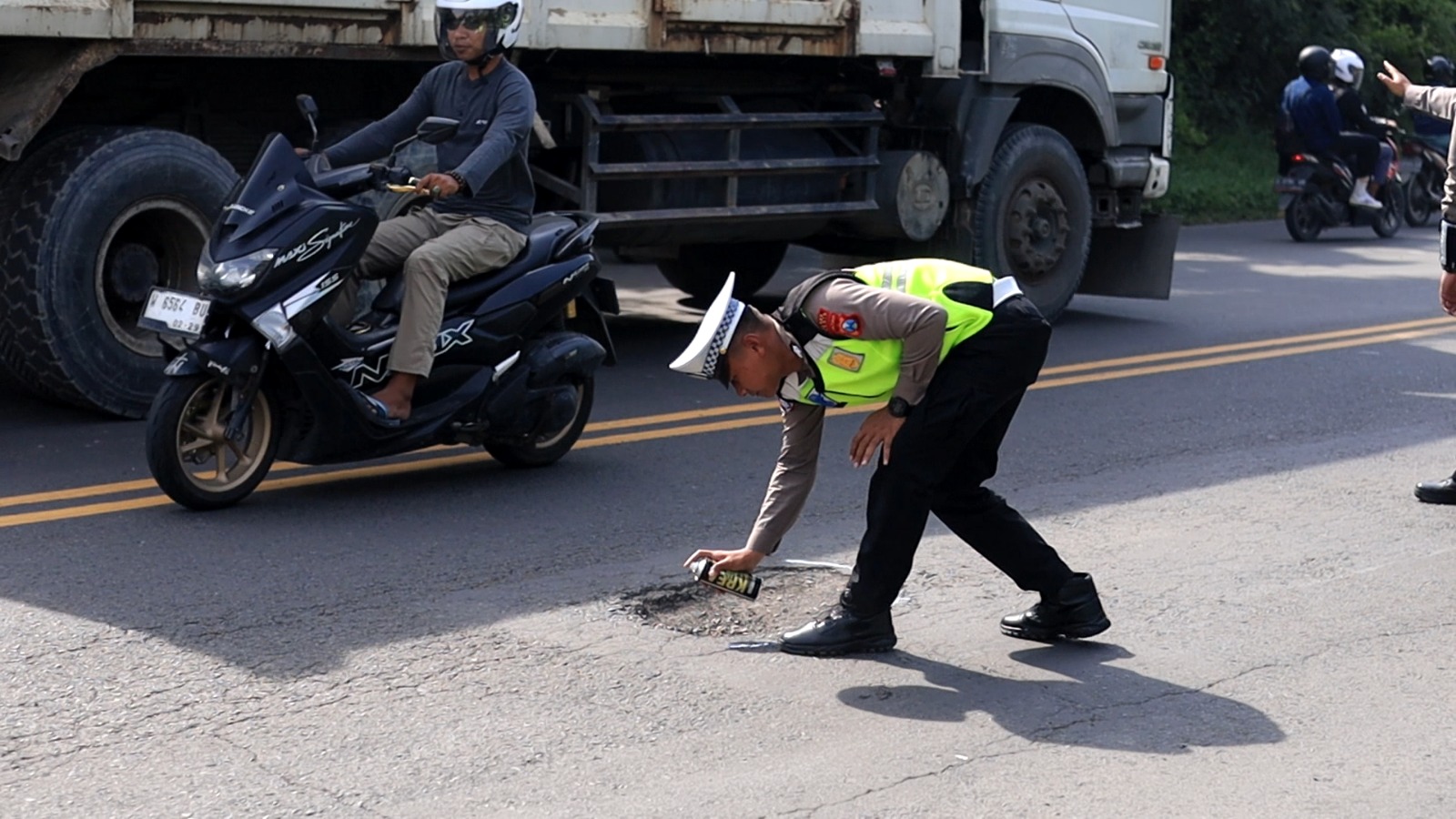 DITANDAI : Anggota Satlantas Polres Gresik saat menandai jalan berlubang di Raya Deandles Demi Keselamatan Pengendara jelang Nataru.