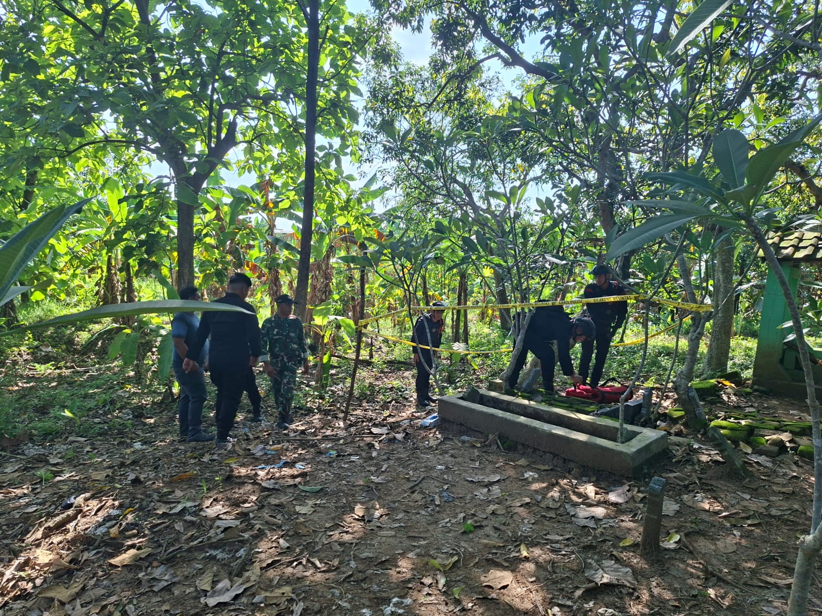 DIMUSNAHKAN : Tim Gegana Unit Jibom Satbrimob Polda Jatim melakukan evakuasi dan memsubahkan sebuah granat nanas di area makam Desa Setro, Kecamatan Menganti, Gresik.