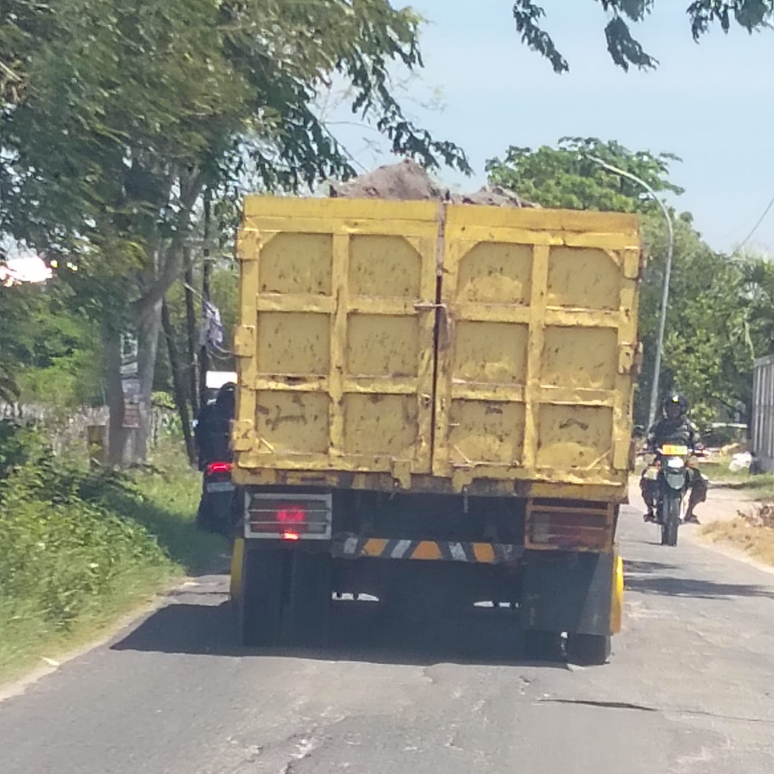 BERKELIARAN: Salah satu armada angkutan galian C saat melintas di wilayah Gresik Selatan tanpa menggunakan penutup terpal, yang membahayakan pengendara lain dan merusak jalan.