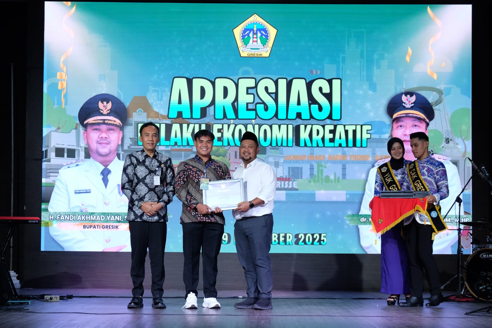 Bupati Gresik Fandi Akhmad Yani didampingi Kepala Dinas Parekrafbudpora drg. Saifudin Ghozali memberikan penghargaan kepada salah satu pelaku ekonomi kreatif.