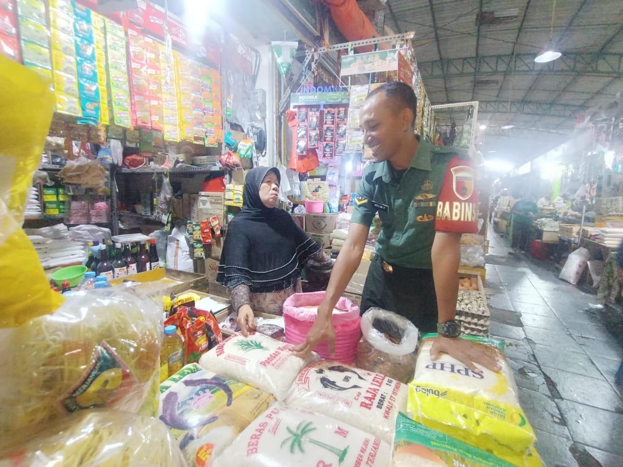 STABIL : Babinsa Kota Gresik melakukan monitoring untuk harga beras di pasar baru Gresik.