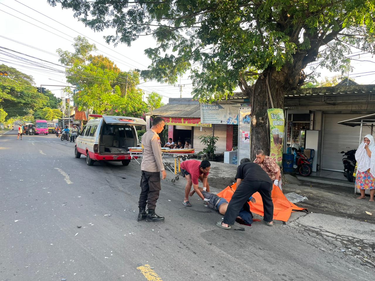 EVAKUASI: Anggota Polsek Panceng saat melakukan evakuasi korban dibantu warga dan petugas medis di Jalan Raya Deandles SP4 Prupuh, Kecamatan Panceng, Kabupaten Gresik.
