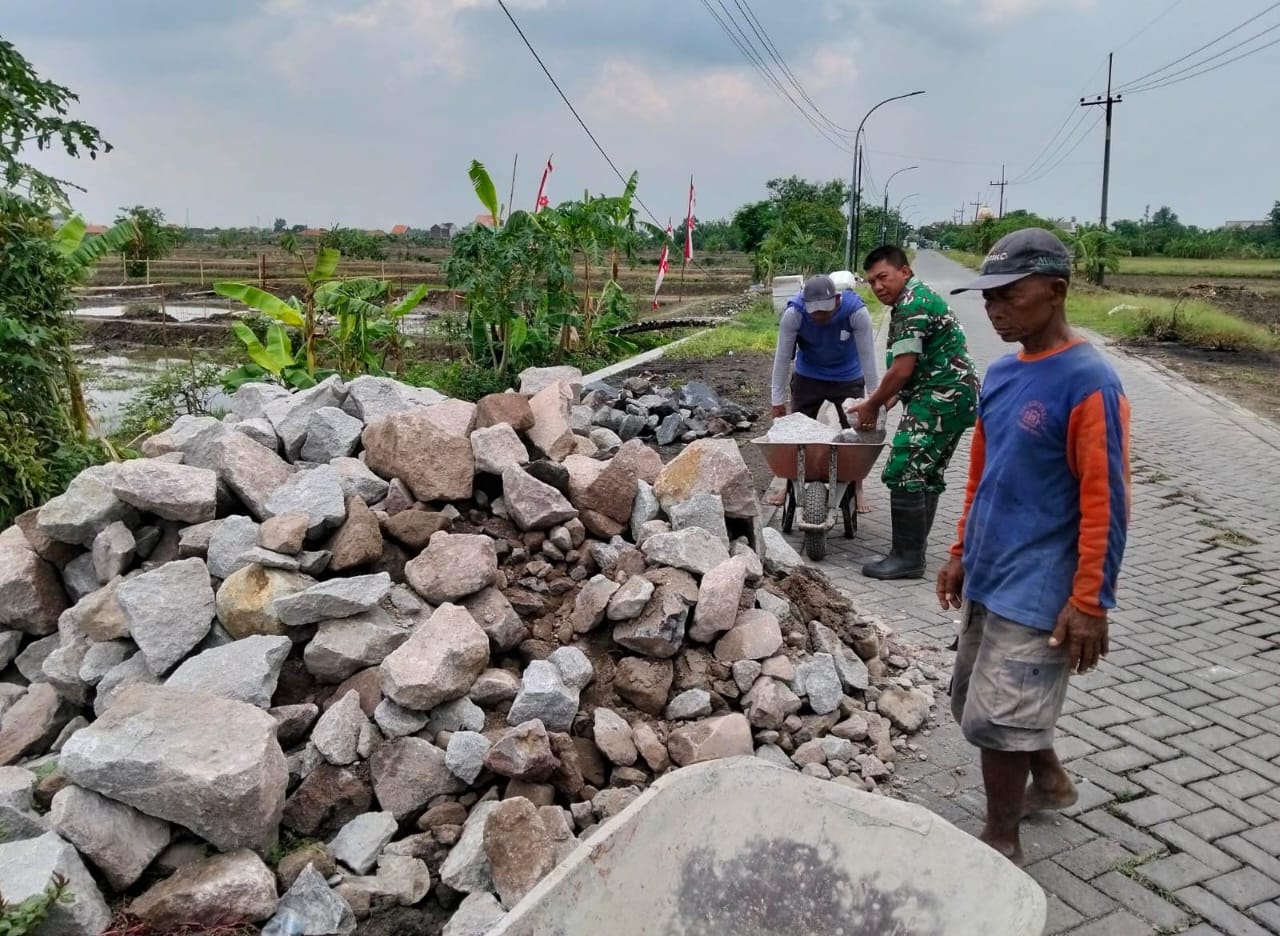 KERJA BAKTI : Anggota TNI kerja bakti untuk membuat struktur pembangunan plengsengan jalan.