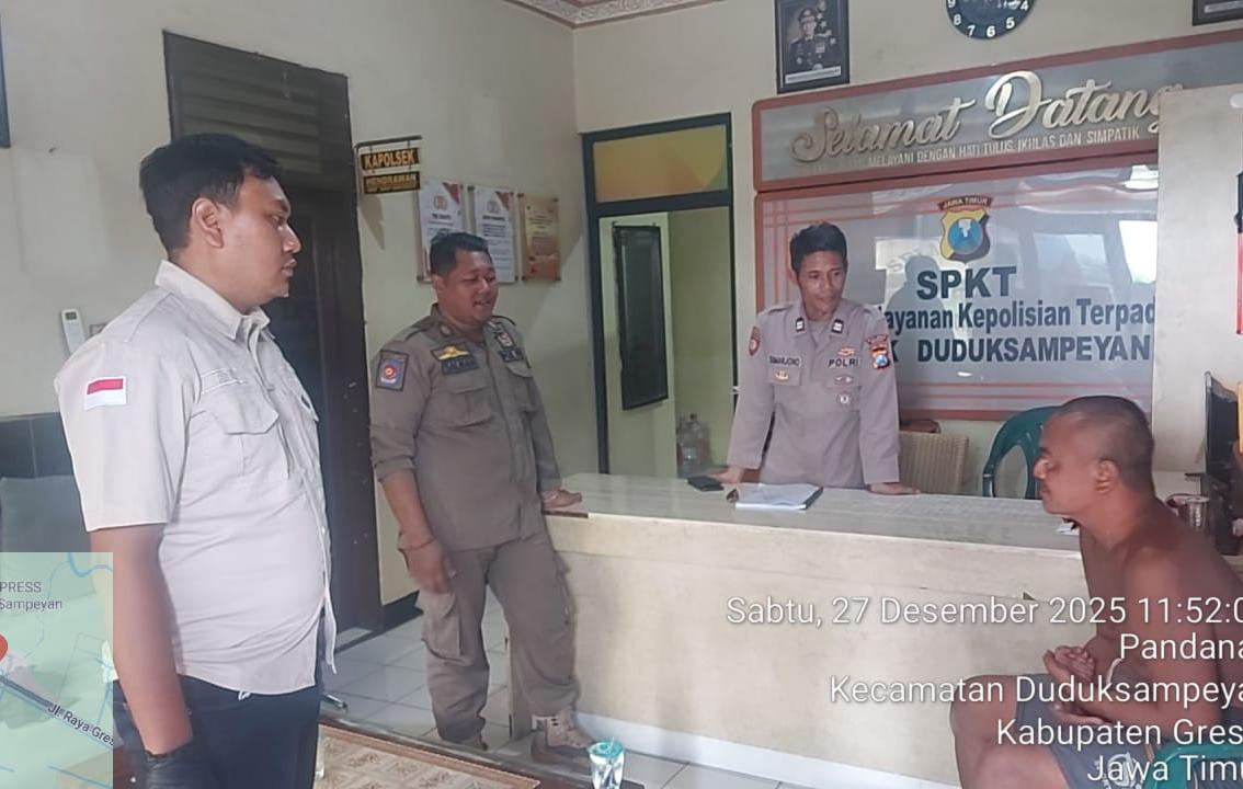 DIAMANKAN: Anggota Polsek Duduksampeyan saat mengamankan ODGJ yang mengamuk dan melempar batu ke kaca mobil pengendara di Jalan Raya Setrohadi, Duduksampeyan, Gresik.
