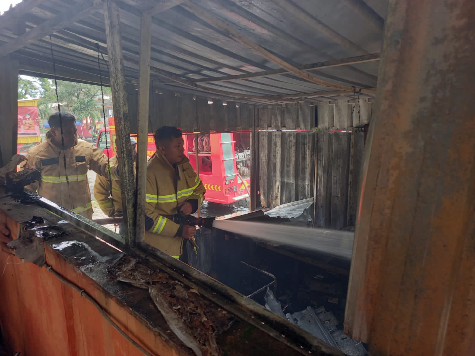 PEMADAMAN &mdash; Petugas Damkar Kabupaten Gresik saat memadamkan kebakaran warung kontainer di Perumahan KBD, Jalan Permata Blok AC Nomor 11, Desa Petiken, Kecamatan Driyorejo, Kabupaten Gresik.