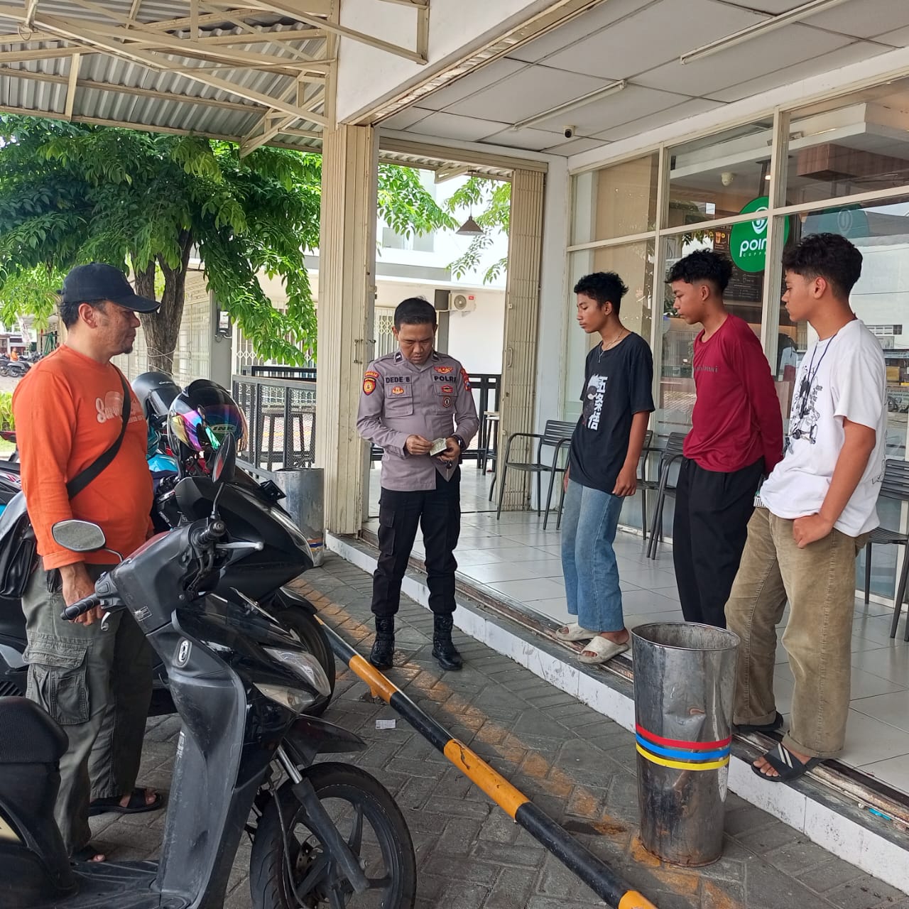 TERTUKAR : Anggota Polsek Manyar saat mendatangi lokasi kejadian terkait kasus tertukar sepeda motor warga yang terparkir di Indomaret, Kecamatan  Manyar, Gresik.