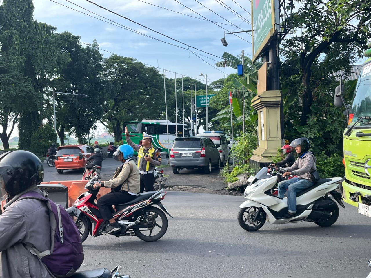 ATUR LALIN : Anggota Satlantas Polres Gresik tengah melakukan pengaturan arus lalu lintas dan pengawasan intensif di Simpang Bunder.