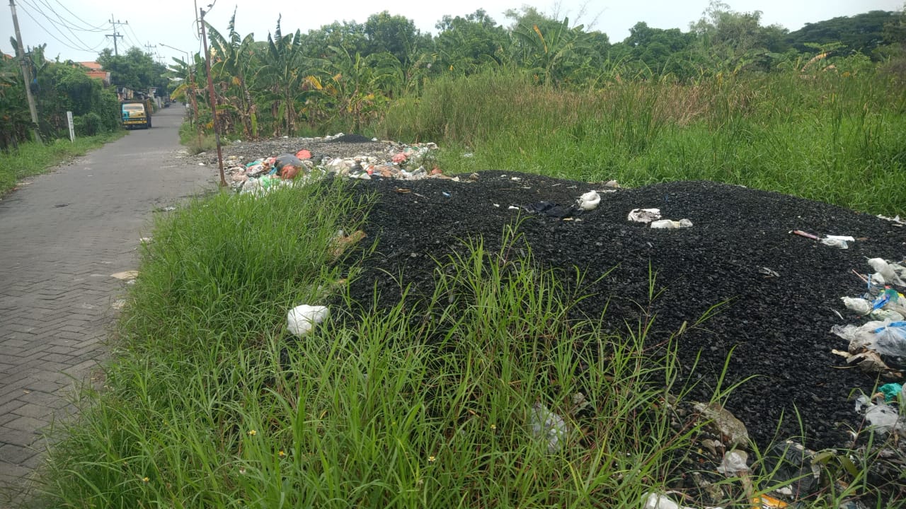MENUMPUK : Material padat berwarna hitam yang diduga limbah B3 ditemukan menggunung di pinggir jalan Kelurahan Prambangan, Kebomas.