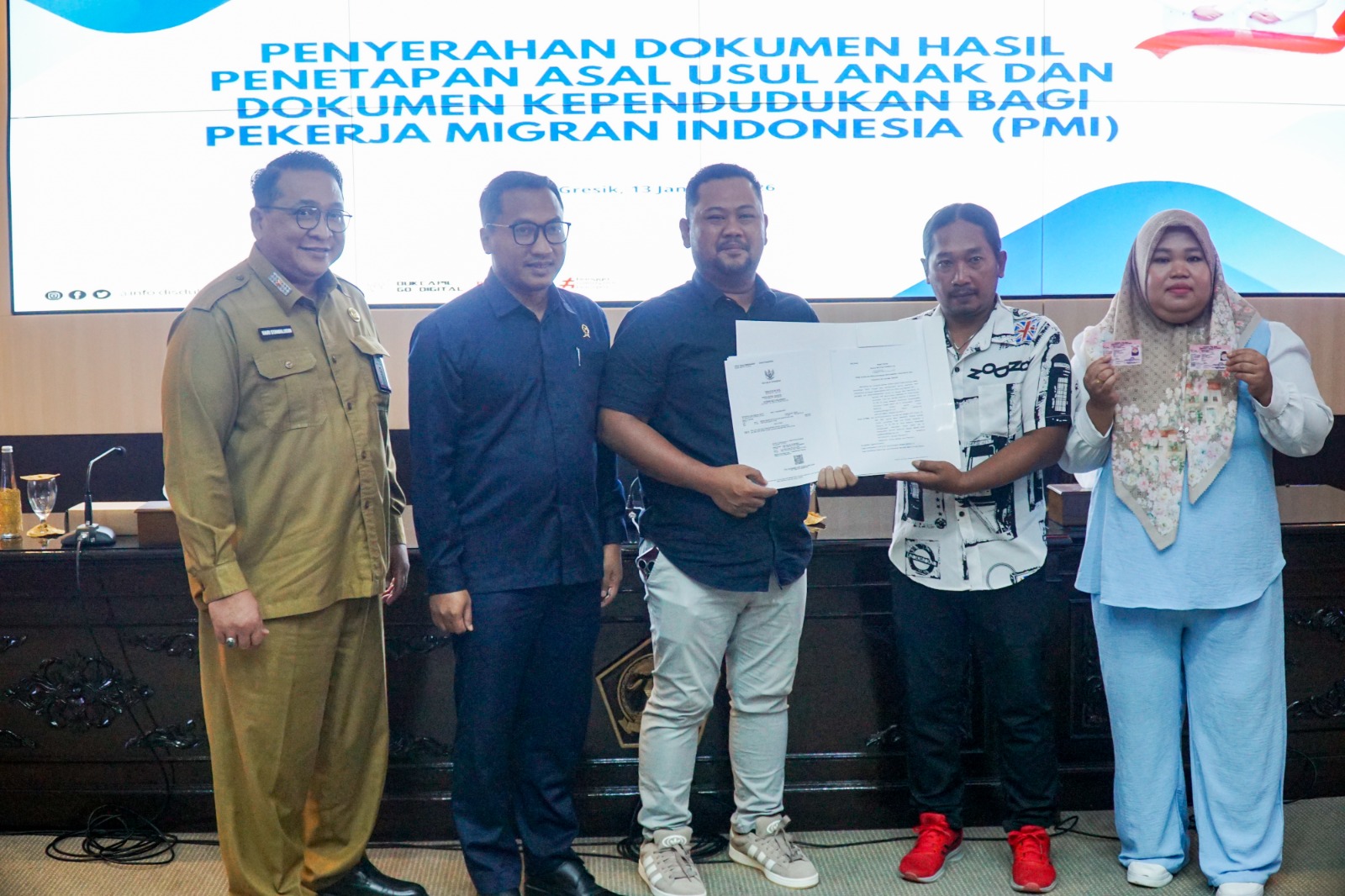 PEDULI: Bupati Gresik Fandi Akhmad Yani  menyerahkan dokumen kependudukan bagi PMI sebagai bentuk perlindungan hukum dan kepastian identitas.
