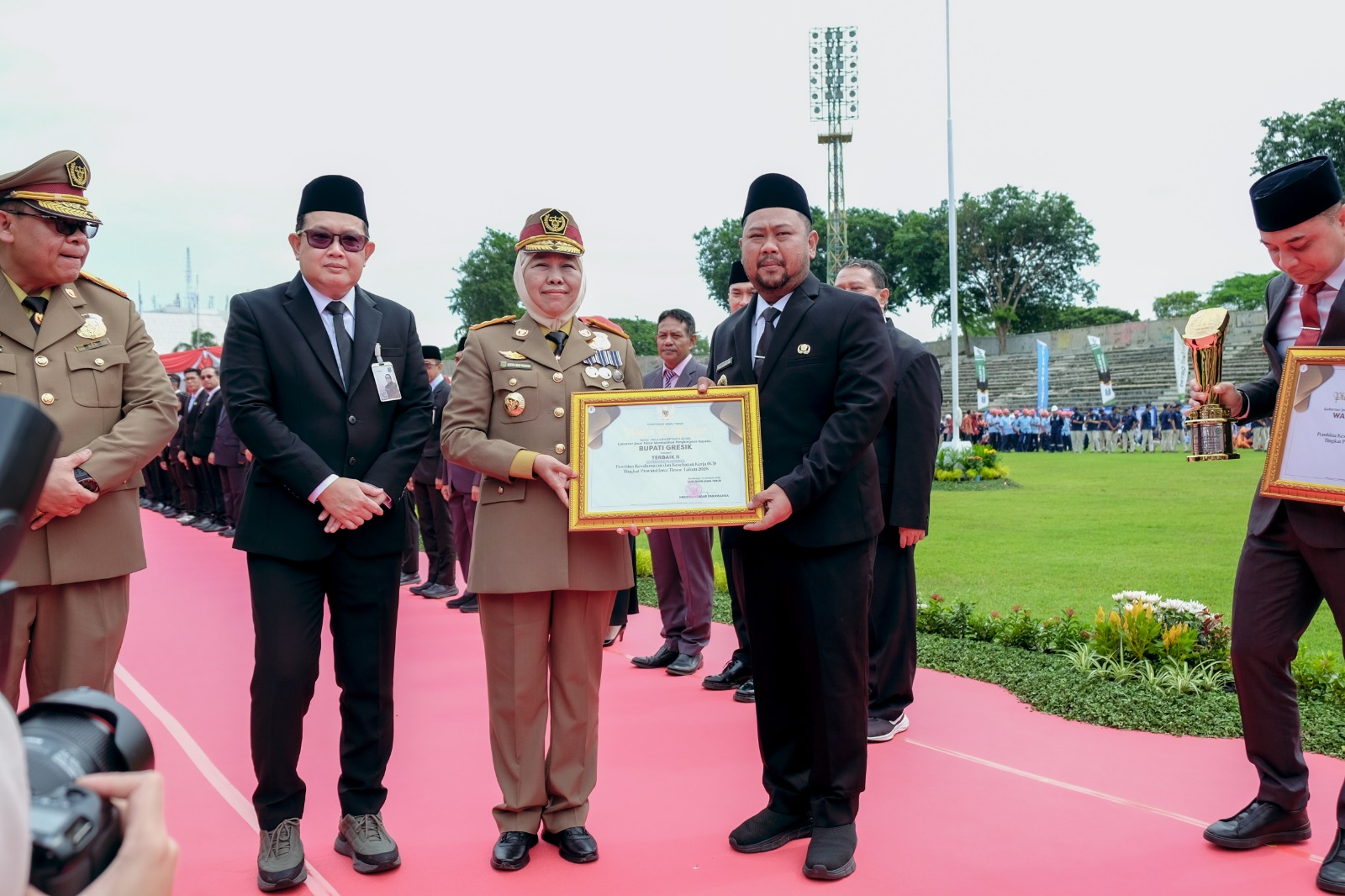 BANGGA: Gubernur Jatim Khofifah menyerahkan Penghargaan Pembina K3 Terbaik II Kategori Platinum dalam ajang Penghargaan K3 Tingkat Provinsi Jatim 2026 kepada Bupati Gresik Fandi Akhmad Yani.