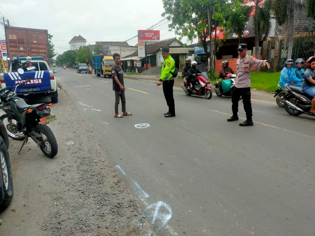 OLAH TKP : Anggota Satlantas Polres Gresik saat melakukan olah TKP dan mengevakuasi korban kecelakaan di depan Apotek Toko Sembayat.