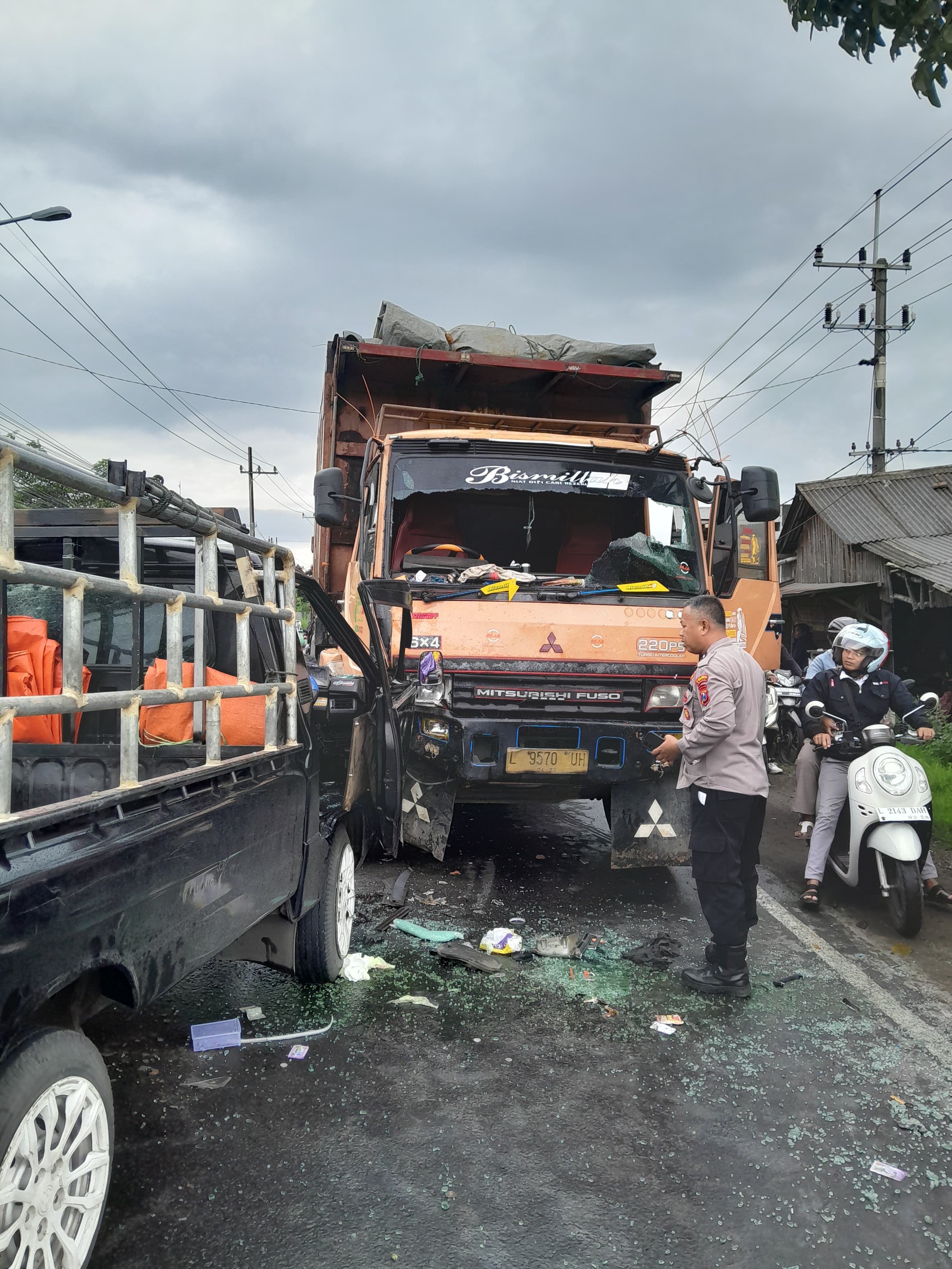 RINGSEK : Petugas kepolisian saat melakukan evakuasi korban dan mobil terlibat kecelakaan dengan kondisi ringsek di Jalan Raya kedamean, depan RS sumber sehat kedamean, Gresik.