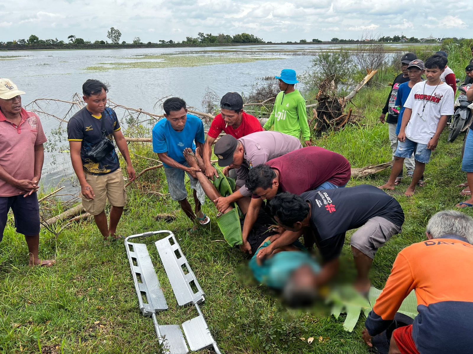 DIEVAKUASI : Anggota Polsek Balongpanggang bersama warga dan tim medis saat mengevakuasi korban tenggelam saat memancing di Waduk Gogor, Dusun Gogor, Desa Wonorejo,