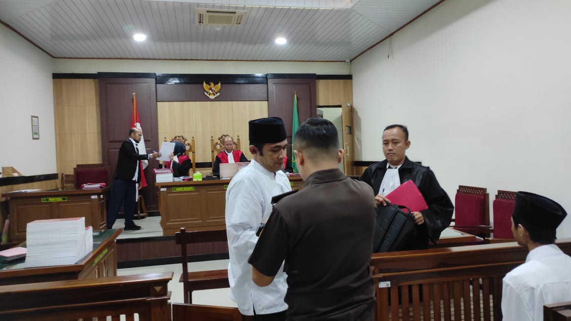 TUNTUTAN : Terdakwa Ahmad Midhol saat dikawal petugas Kejari Gresik usai menjalani sidang Tuntutan di PN Gresik.
