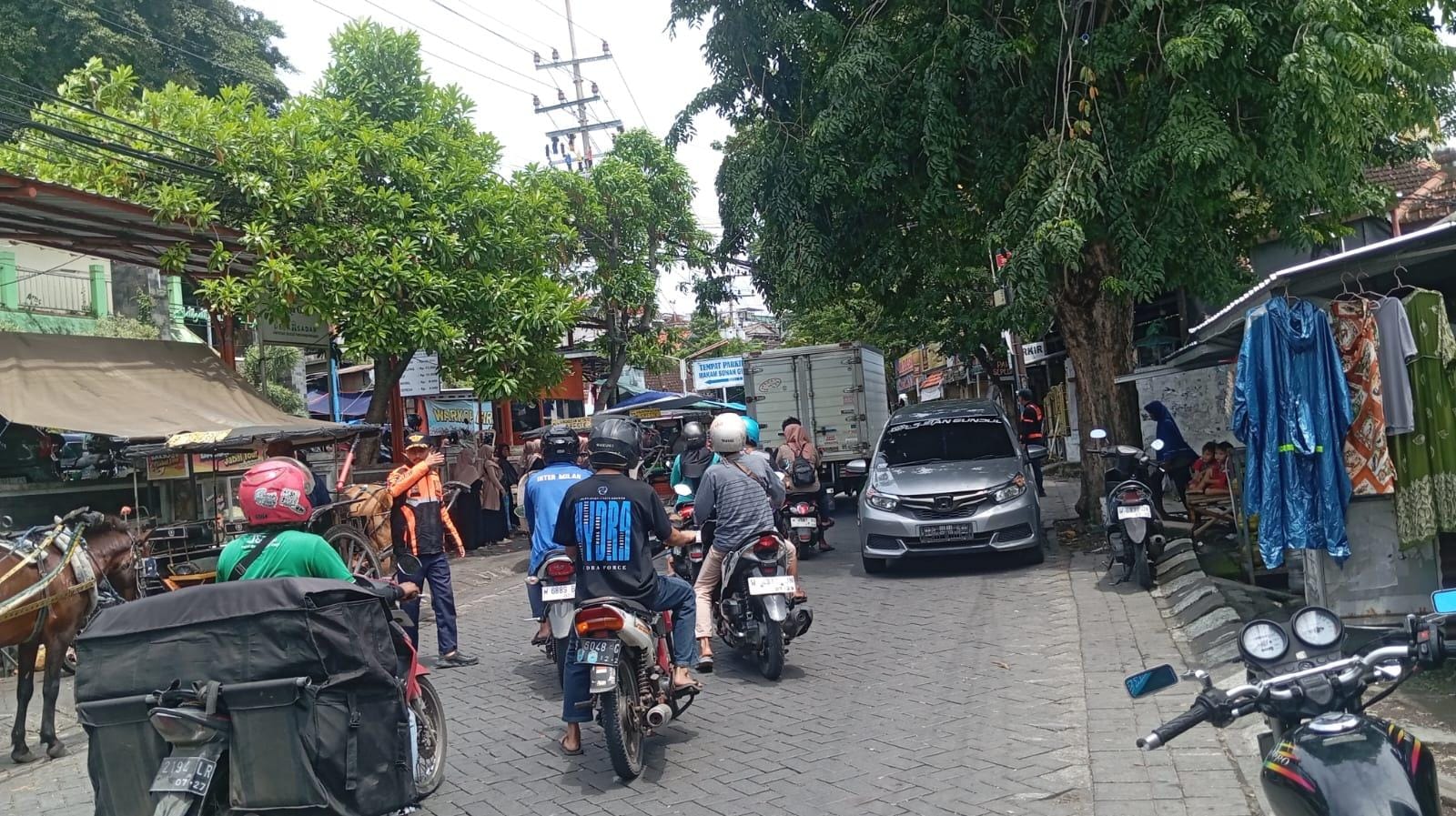 MENGATUR : Petugas Dishub Gresik saat mengatur lalu lintas di kawasan Jalan Sunan Giri.