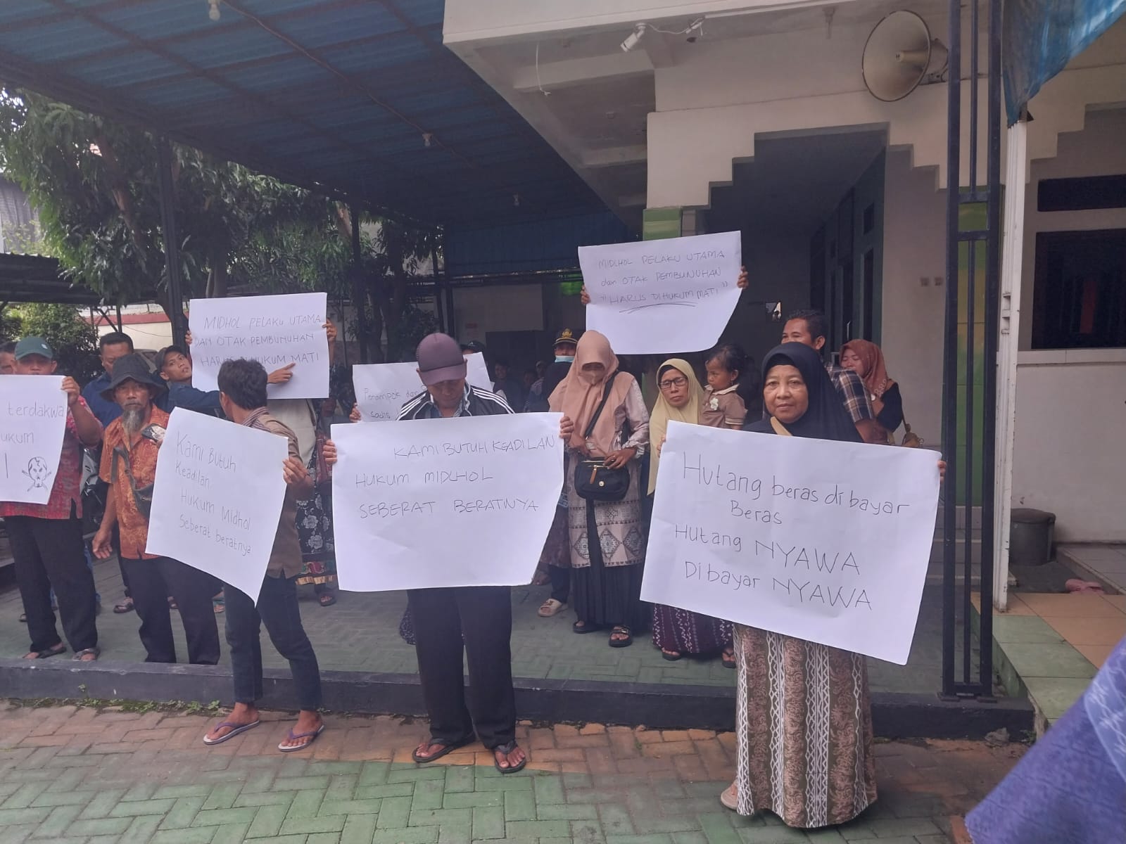 DEMO : Puluhan warga Desa Imaan, Kecamatan Dukun menggelar aksi demo di PN Gresik sebagai bentuk protes atas tuntutan JPU Kejari Gresik terhadap terdakwa Midhol yang dianggap ringan.