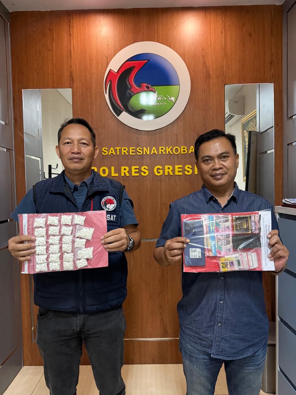 DIAMANKAN :Anggota Satreskoba Polres Gresik saat mengamankan barang bukti berupa 1.169 pil dobel L dari tangan tersangka yang diamankan.